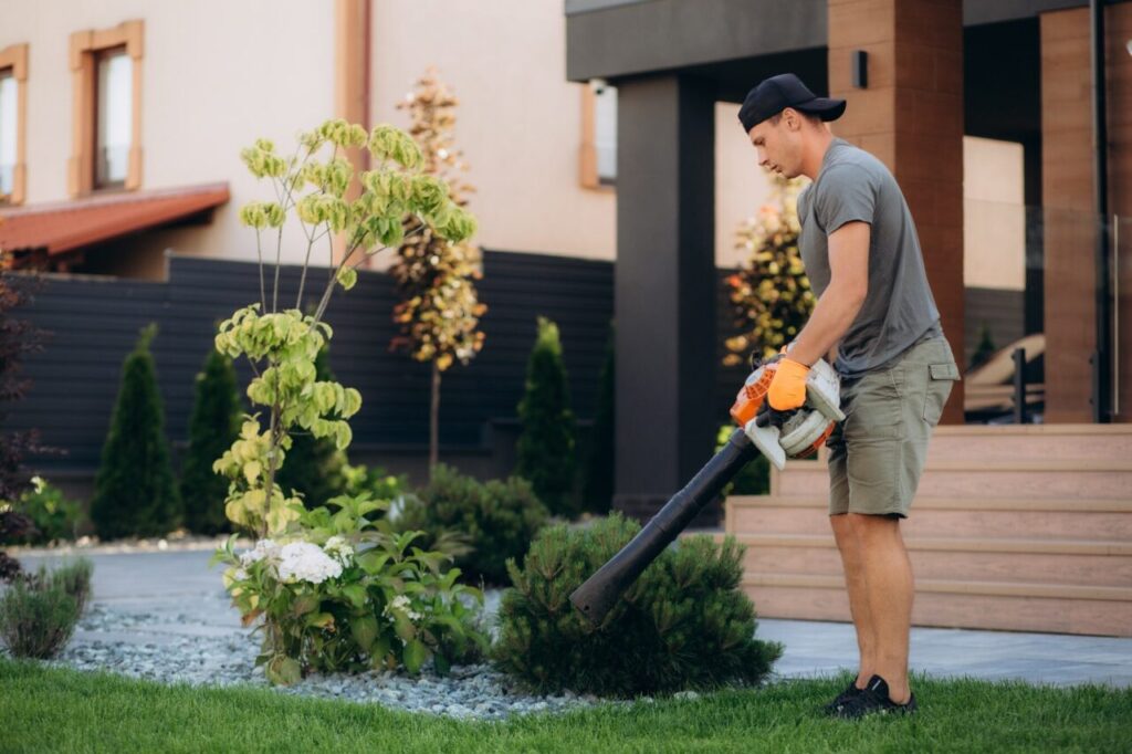Gardener using his leaves blower in the garden